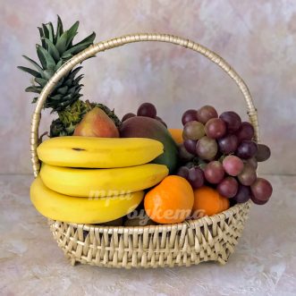 Ананас, виноград и бананы в корзине